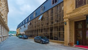 A hotel facade with large windows, a red carpet entrance, and a classic architectural style. - Renessans Hotel Baku (Baku)