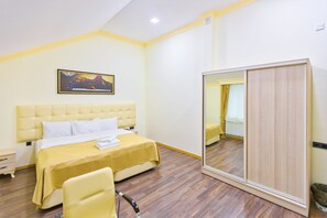 A hotel room with a bed, a chair, a mirror, and a painting on the wall. - Renessans Hotel Baku (Baku)