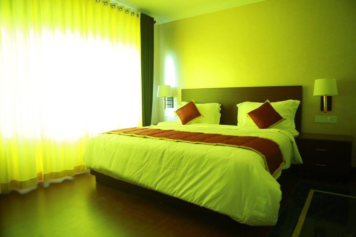 A hotel room with a bed, two bedside tables, and a nightstand.