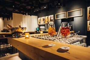 A bar area with glasses of drinks and a candle on the counter. - VILOTEL - Hotel & Restaurant (Oberkochen)