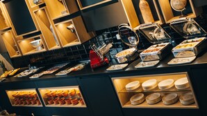 A buffet area with various food items and utensils, including bowls, plates, and a red appliance. - VILOTEL - Hotel & Restaurant (Oberkochen)