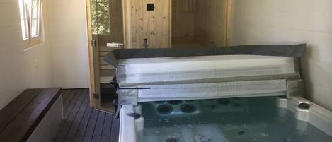 Un jacuzzi en una habitación con paredes y terraza de madera.