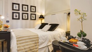 A neatly arranged hotel room with a bed, bedside table, and a tray with breakfast items. - Luxury B&B room at Colosseum bathroom ensuite (Roma)