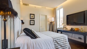 A hotel room with a bed, a desk, a TV, and a lamp. - Luxury B&B room at Colosseum bathroom ensuite (Roma)