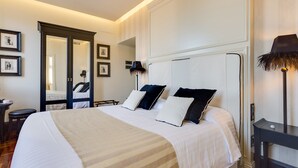 A hotel room with a large bed, a bedside table, a mirror, and framed pictures on the wall. - Luxury B&B room at Colosseum bathroom ensuite (Roma)