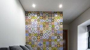 Un intérieur moderne avec un canapé gris, un mur à motifs et une porte en bois.