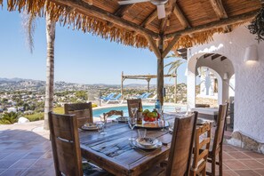 Enjoy meals al fresco with a view of the town and mountains from this outdoor dining area overlooking the pool.