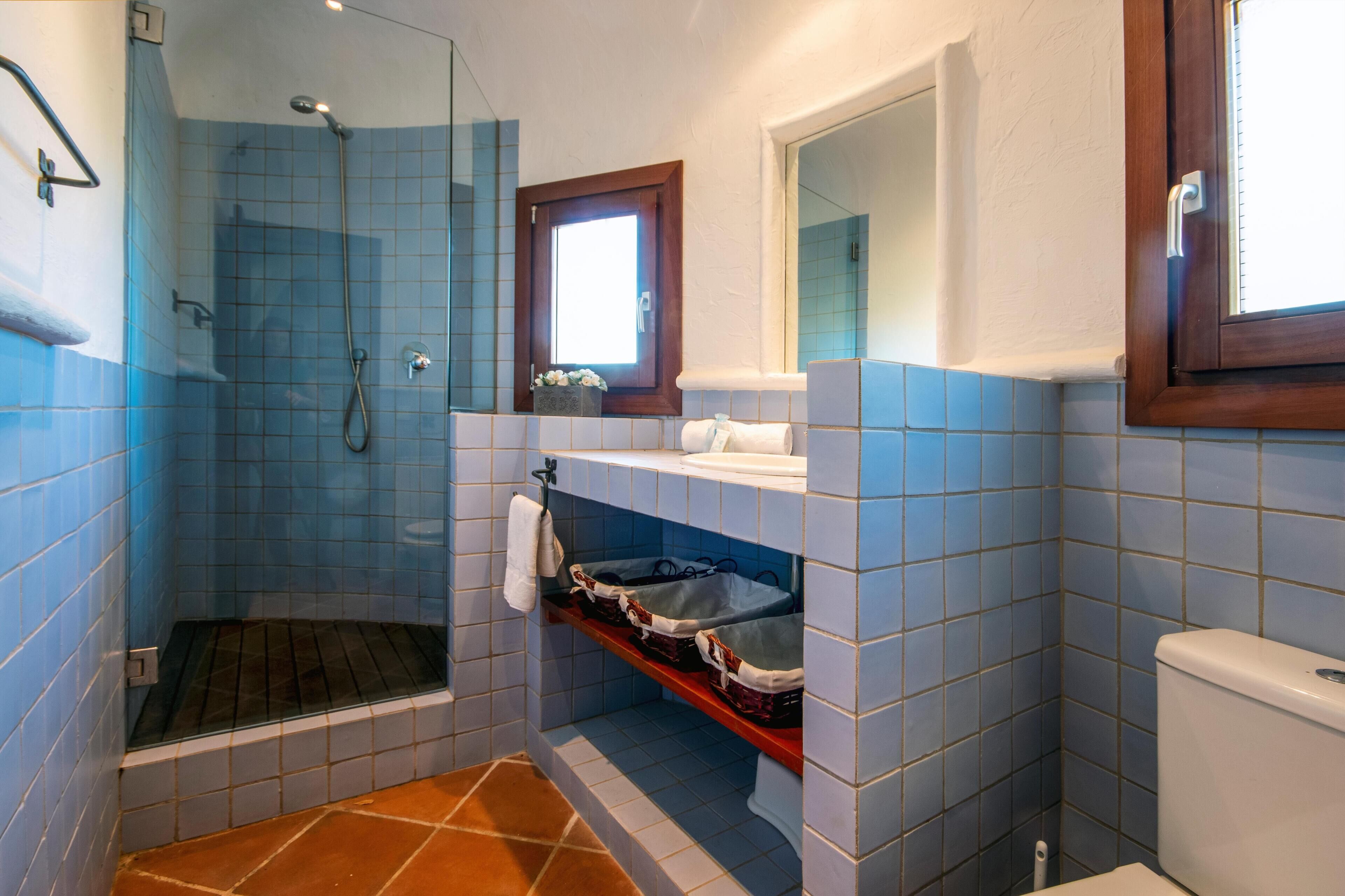 Une salle de bain équipée d’une douche, de toilettes et d’un lavabo avec un miroir au-dessus.