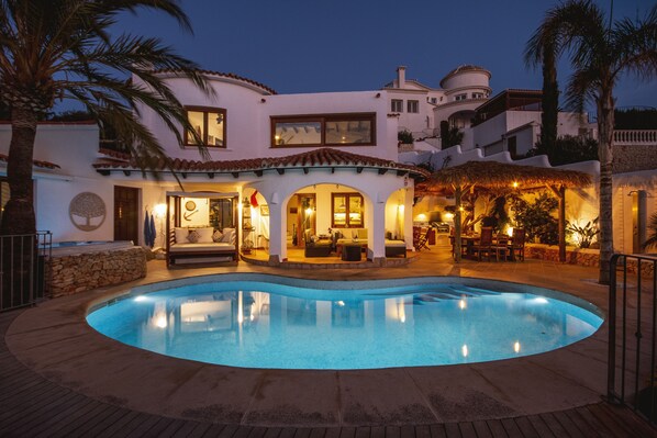 Relax by the resort's inviting pool surrounded by lush palm trees and comfortable outdoor seating areas.