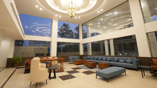 Eine großzügige Lobby mit hoher Decke, großen Fenstern und einem Kronleuchter.