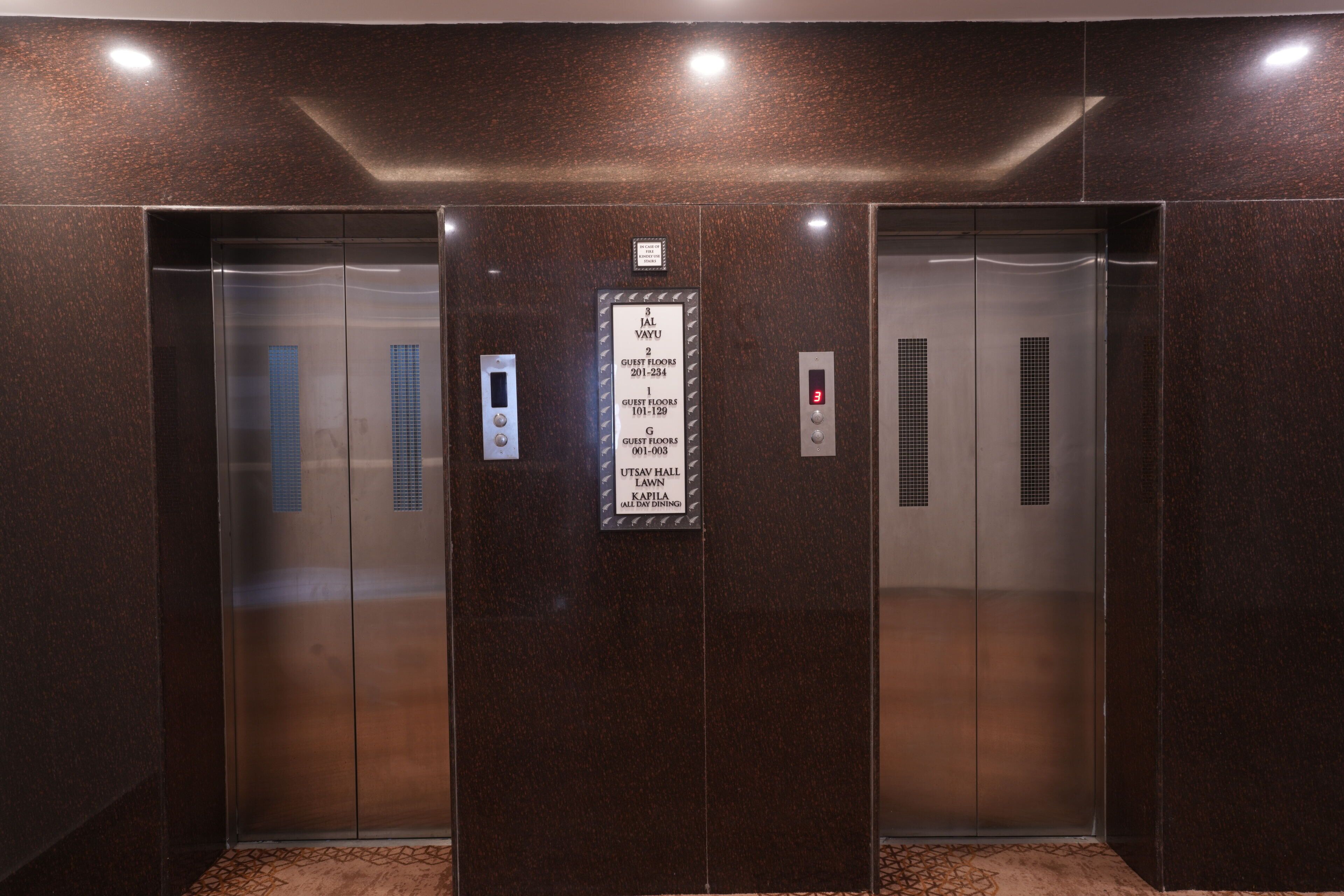 An elevator with a sign indicating guest floors and a digital display.