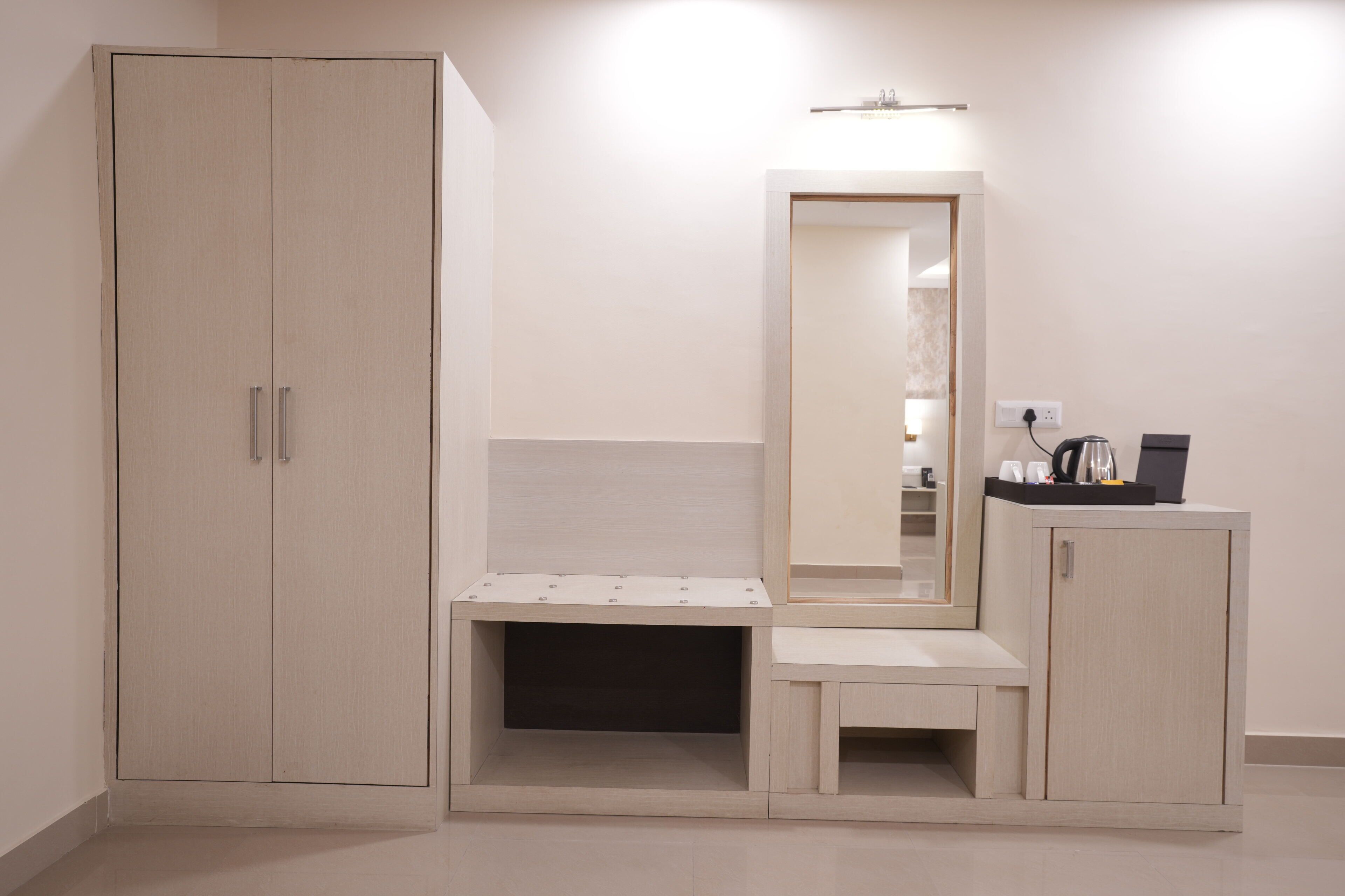 Un dormitorio con armario, mesita de noche, espejo y un pequeño mueble.