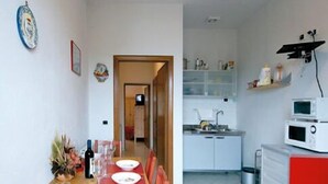 A compact living space with a dining area and kitchenette. - Residence La Mezzaluna (Barga)