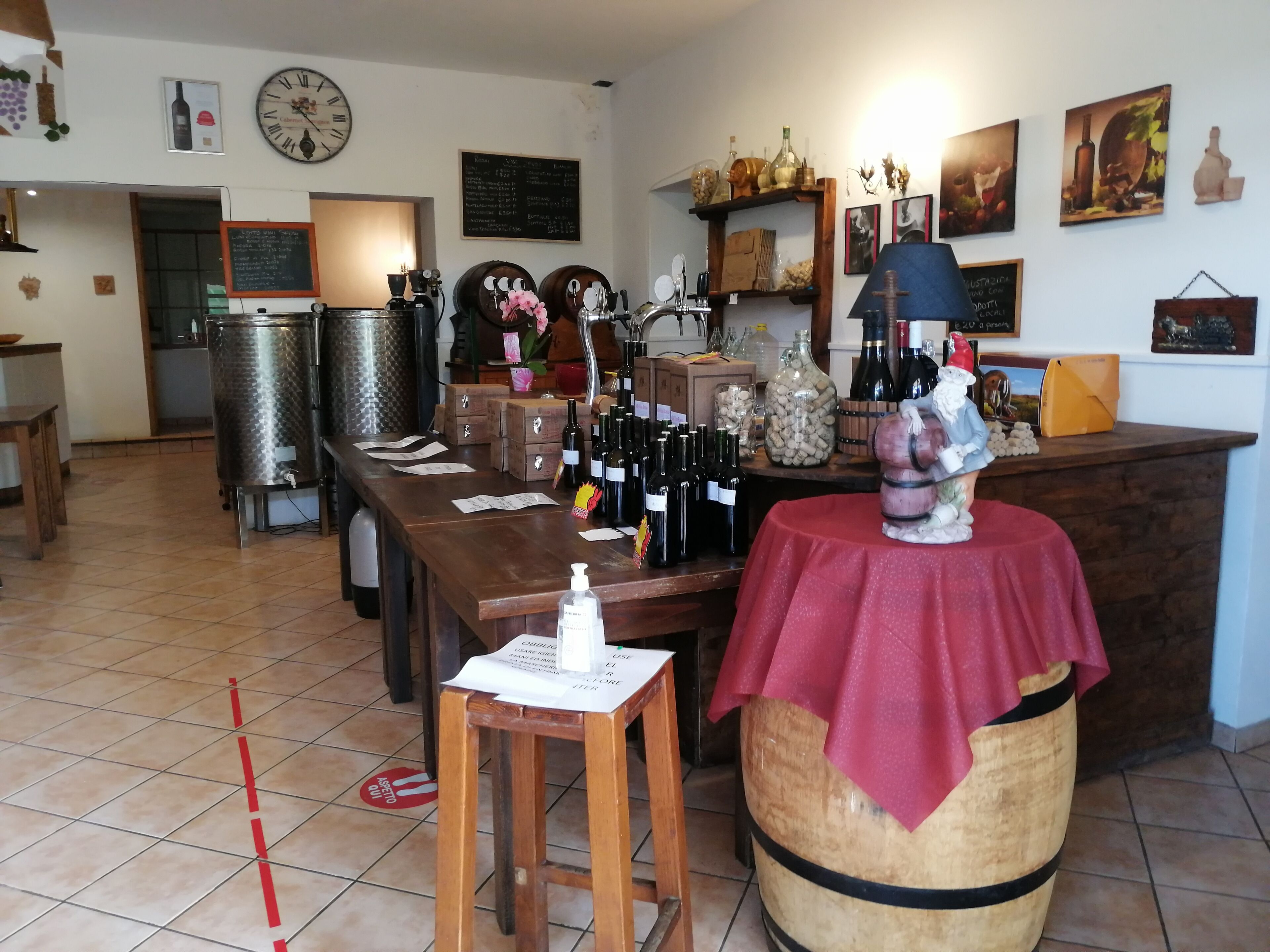 A wine cellar with wooden barrels, wine racks, and a variety of wine bottles.