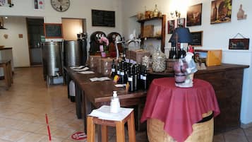 A wine cellar with wooden barrels, wine racks, and a variety of wine bottles.