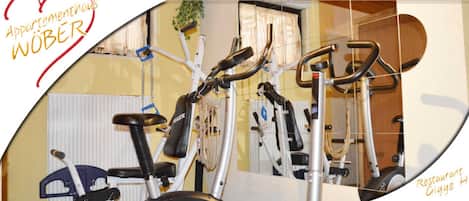 Une salle de sport équipée de vélos d’appartement et d’appareils d’exercice.