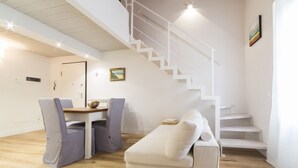 Un intérieur moderne avec un escalier, un coin repas et un canapé.