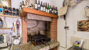 A kitchen with a brick oven, wine bottles on shelves, and various cooking utensils. - Beach front apartment in Starigrad with WiFi (Starigrad)