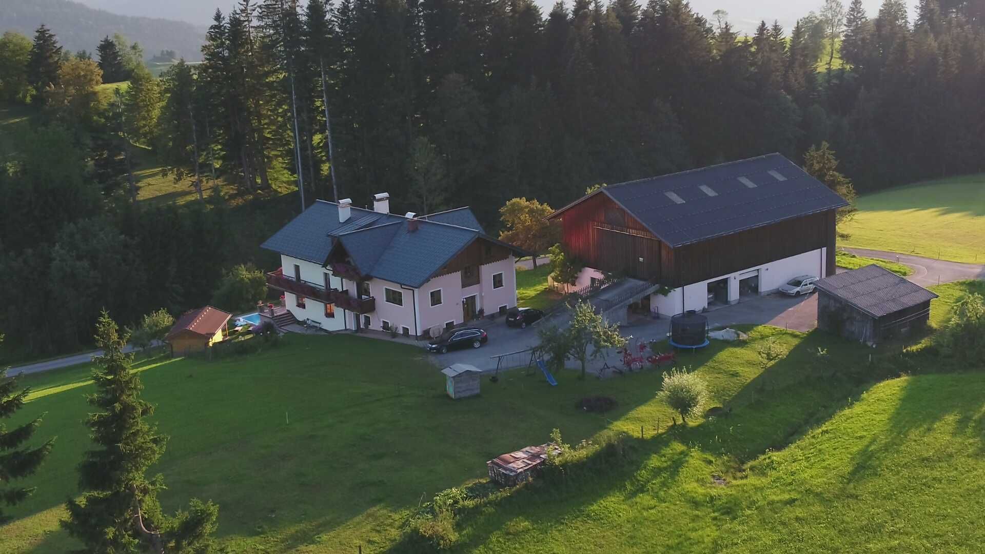 Une grande maison avec un garage, une piscine et un trampoline dans le jardin.