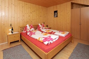 Une chambre à coucher aux murs lambrés, avec un lit, des tables de chevet et une armoire.