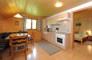 L’intérieur d’un chalet confortable comprend un coin repas, une cuisine et un lit.