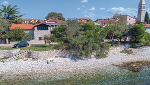 A coastal town with stone buildings, a church with a bell tower, and a clear beach. - Gorgeous apartment in Lovrecica with WiFi (Lovrecica)