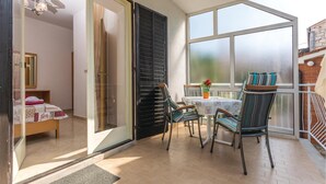 A room with a bed, a small table with a potted plant, and a window with a view. - Gorgeous apartment in Lovrecica with WiFi (Lovrecica)