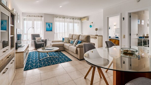 A modern living room with a sofa, a coffee table, and a glass dining table. - TOP - APARTMENT VISTA PRAIA WITH FANTASTIC SEA VIEWS (Armacao de Pera)