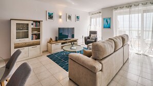 A modern living room with a sofa, TV, and bookshelf. - TOP - APARTMENT VISTA PRAIA WITH FANTASTIC SEA VIEWS (Armacao de Pera)