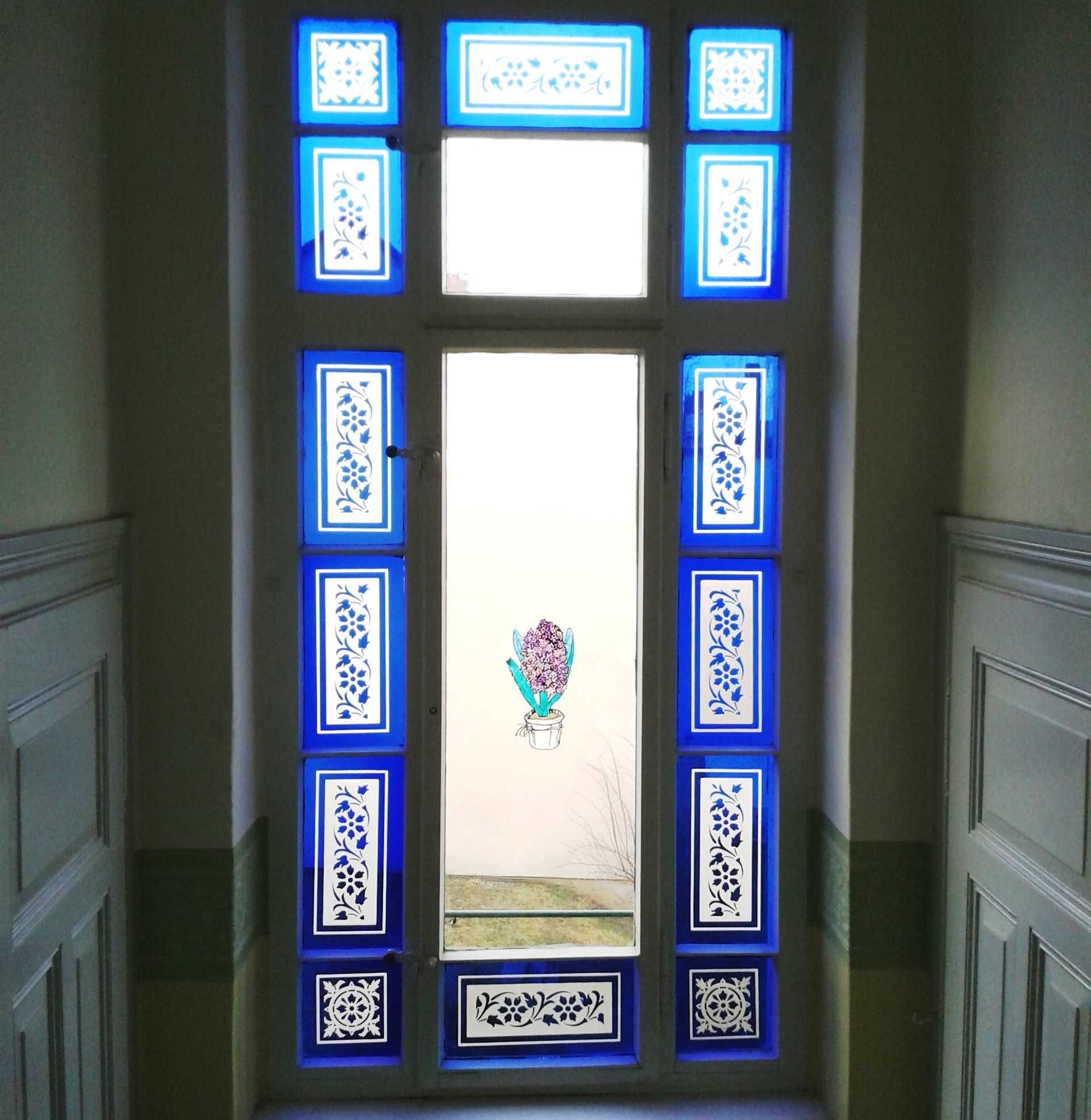 A door with blue decorative panels and a potted plant in the center.