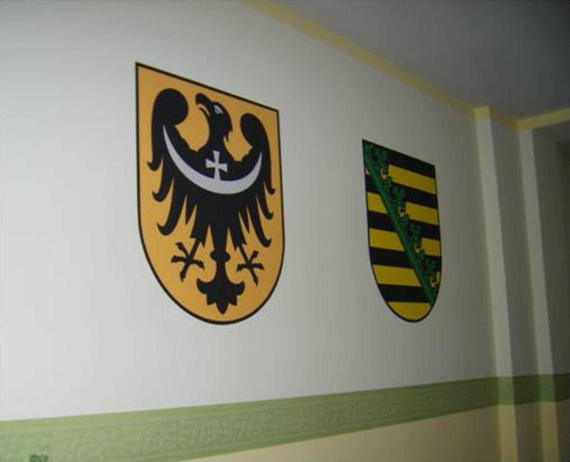 Zwei Wappen an einer Wand.