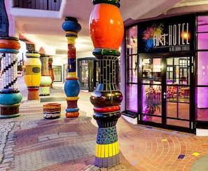 Entrada de hotel con pilares de diseño colorido y único, y un letrero que dice 'ART HOTEL'.
