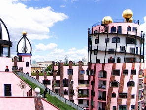 A multi-story building with a pink facade, balconies, and a distinctive golden dome structure.