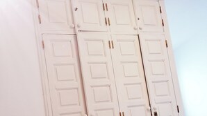 Ein Schlafzimmer mit einem Bett, einer weißen Wand und einem weißen Kleiderschrank mit zwei Türen.