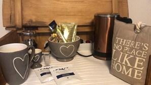 A kitchen counter with a coffee maker, a mug, a thermos, a bag, and tea packets. - McMüller's Kemenate Fulda (Fulda)