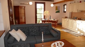 Un salon comprenant un canapé, une table basse et un coin repas avec une table et des chaises.
