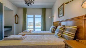 Ein Hotelzimmer mit zwei Betten, Meerblick und einem Balkon.