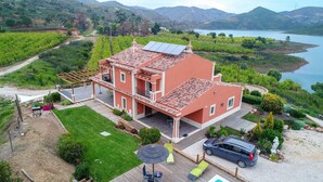 A two-story house with a red roof, solar panels, and a car parked in front. - Luxurious villa with pool and idyllic lake landscape (Silves)