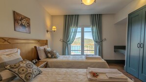 A hotel room with two beds, a view of the outdoors, and a large wardrobe. - Luxurious villa with pool and idyllic lake landscape (Silves)