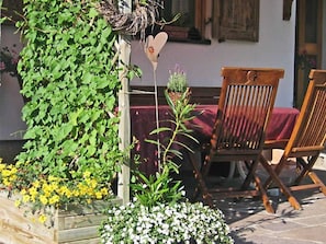 A wooden chair, a heart-shaped decoration, and a wooden planter with plants. - Category B - Zimmer Wollgras - WohlfühlHaus Evelin (Au)