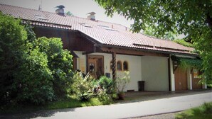 Ein traditionelles Gebäude mit Ziegeldach, einer Veranda und einer Schotterauffahrt.