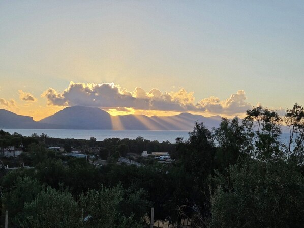 A coastal landscape with mountains in the background, a body of water in the foreground, and a cluster of buildings. - Nice Casa Andrea with beautiful panoramic views of the sea (Balestrate)
