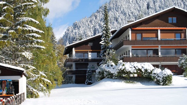 A multi-story building with balconies, surrounded by snow-covered trees and mountains. - Luxury Apartment Alpenblick ***** - Berghaus Tirol (Seefeld in Tirol)