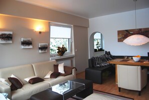 Ein Wohnzimmer mit einer Couch, einem Couchtisch und einem Essbereich mit Tisch und Stühlen.