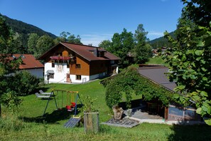 A house with a sloped roof, a swing set, and a small garden. - Apartment 1 - House Maringele (Nesselwängle)