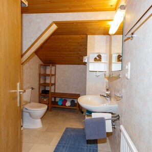 A bathroom with a toilet, sink, wooden shelves, and a towel rack. - Apartment 1 - House Maringele (Nesselwängle)