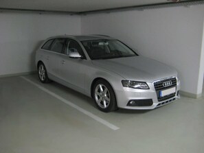 A silver Audi car parked in a parking garage.