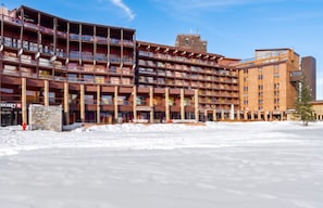 A multi-story hotel with a central atrium and balconies, surrounded by snow.
