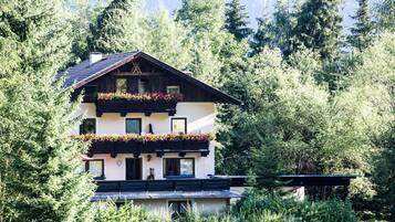 Ein mehrstöckiges Gebäude mit Balkonen, umgeben von dichtem Wald.