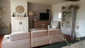Ein Wohnzimmer mit Sofa, Fernseher, Schrank und Dekoration.